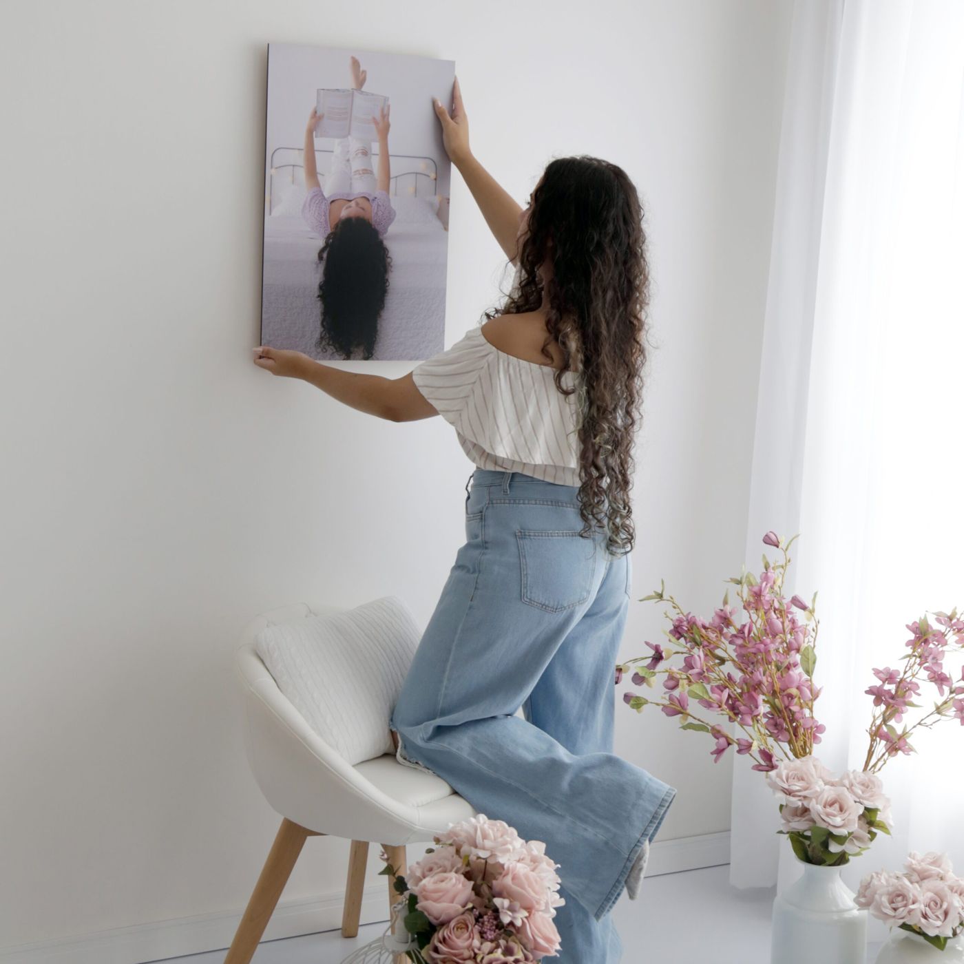 Pessoa pendurando um quadro com foto na parede da sala